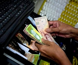 A store owner counts his money in in Caracas on 15 July 2013, as the Venezuela government seeks to make foreign exchange more flexible and accelerate the economy. (Agencia EFE/REX Shutterstock)