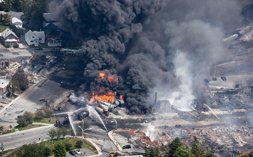 Smoke rises from railway cars that were carrying crude oil after derailing in downtown Lac Megantic 6 Jul 2013 (Canadian Press/REX/Shutterstock) 