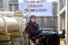 SMALL PHOTO: Not everyone favours the pipeline projects. Protester Jessica Lambert Mascotte sits chained to a pipeline junction of the Trans Northern pipeline project in Oka Provincial Park, Quebec. (Canadian Press/REX/Shutterstock)