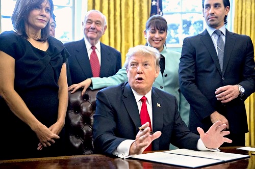 US President Donald Trump signs an executive order on Monday in the Oval Office of the White House. ( REX/Shutterstock)